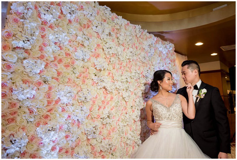 couple in front of flower wall at hei la moon