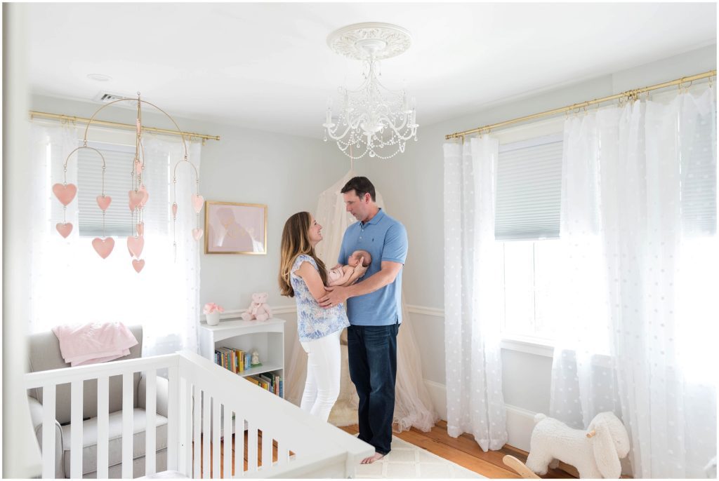 parents holding newborn in nursery. Preparing for a photo session