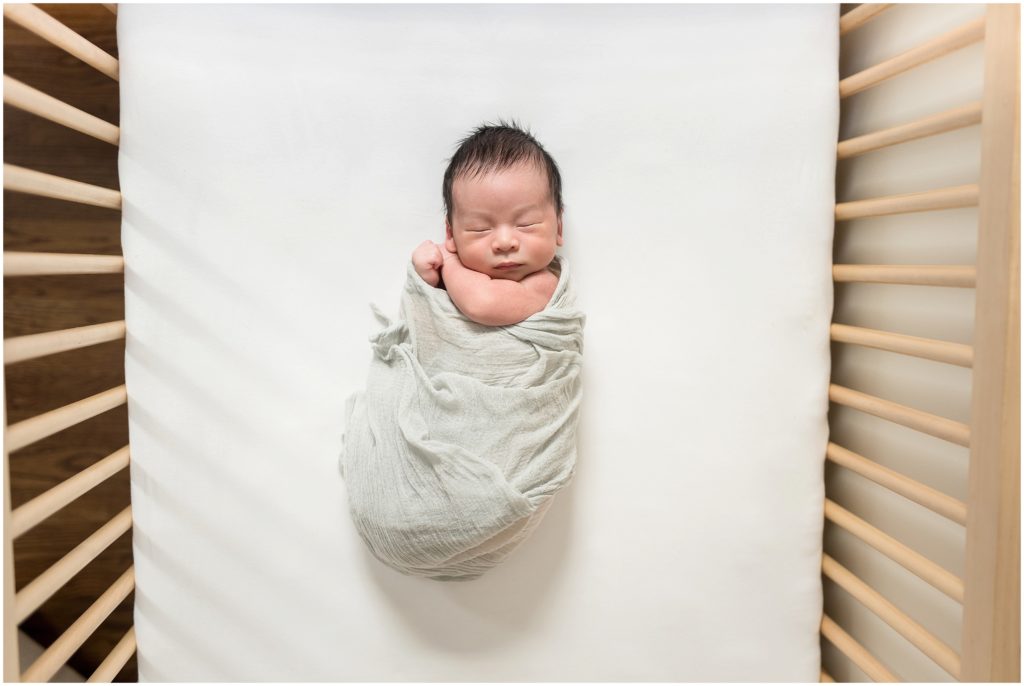 Newborn in crib in nursery