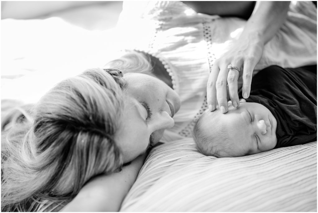 mother stroking son's hair during newborn session
