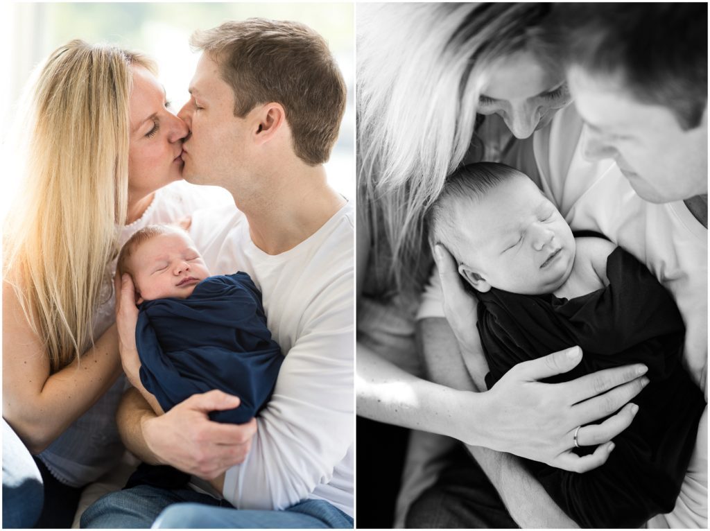 parents holding baby boy on bed kissing