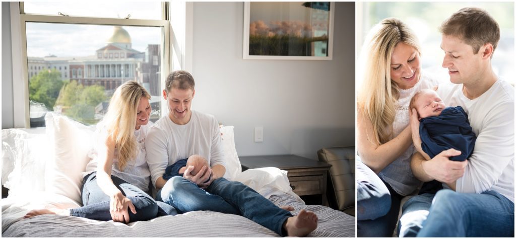 parents holding baby boy in apartment in Boston with state house in background