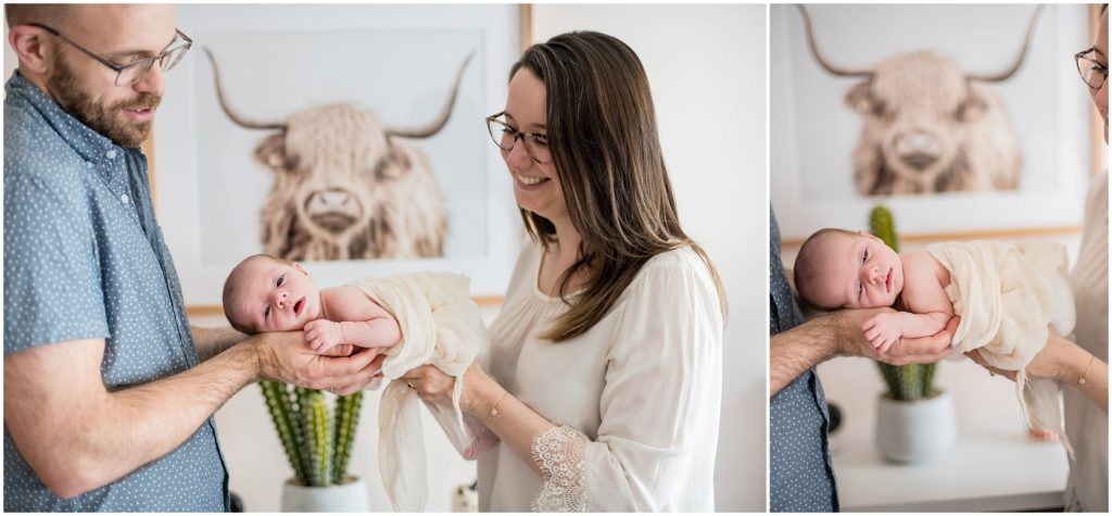 Parents holding baby girl in home in Newton newborn lifestyle session