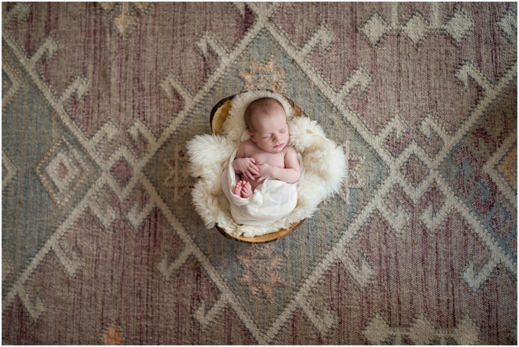 Newborn on rug in nursery