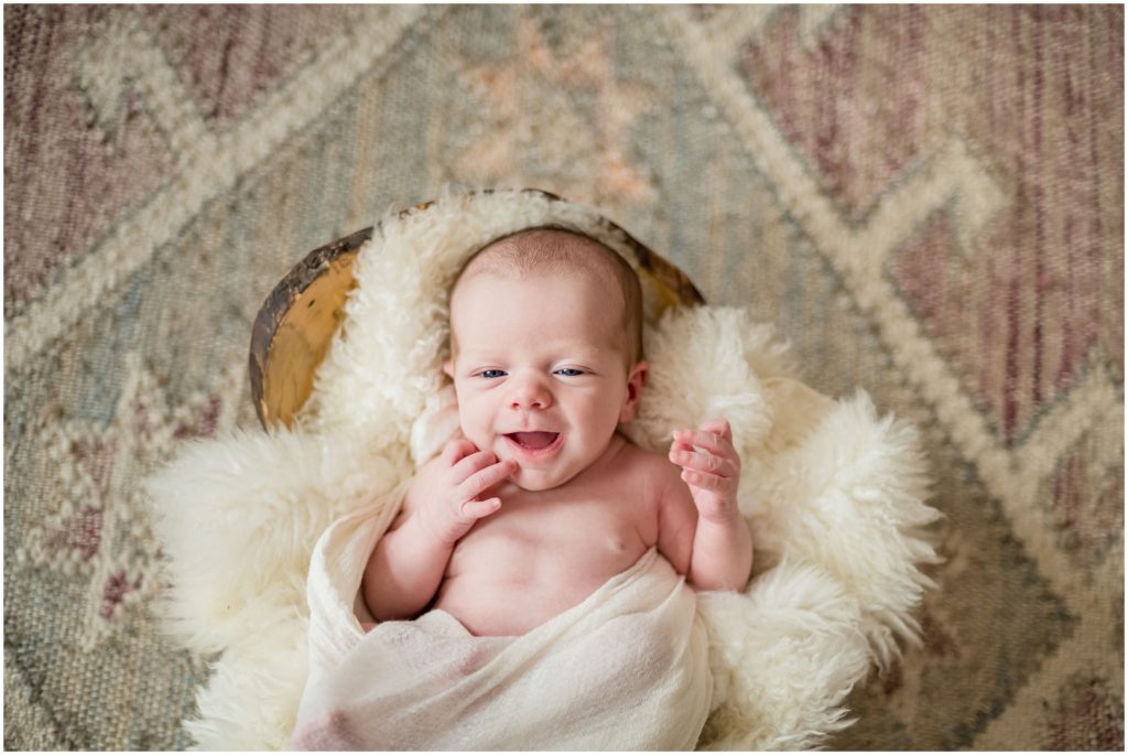 Newborn on rug in nursery in Newton