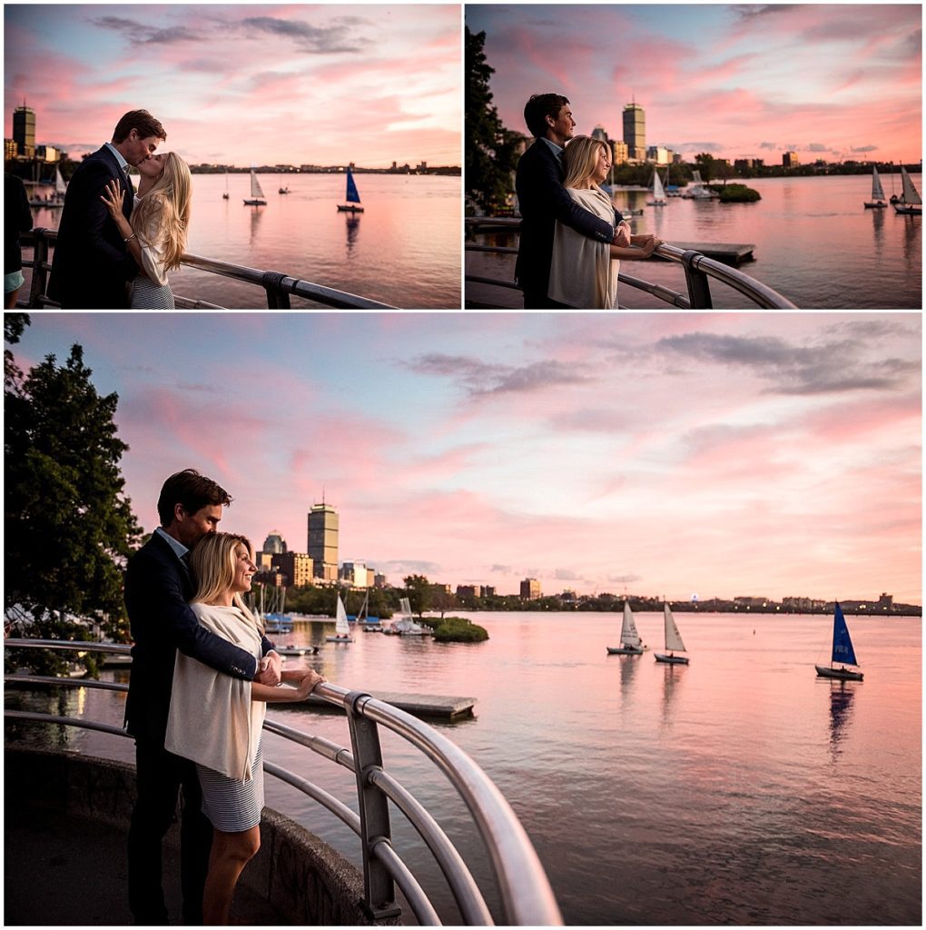 Sunset over the Charles River with boats in the background and city skyline, the couple in the foreground during engagement session