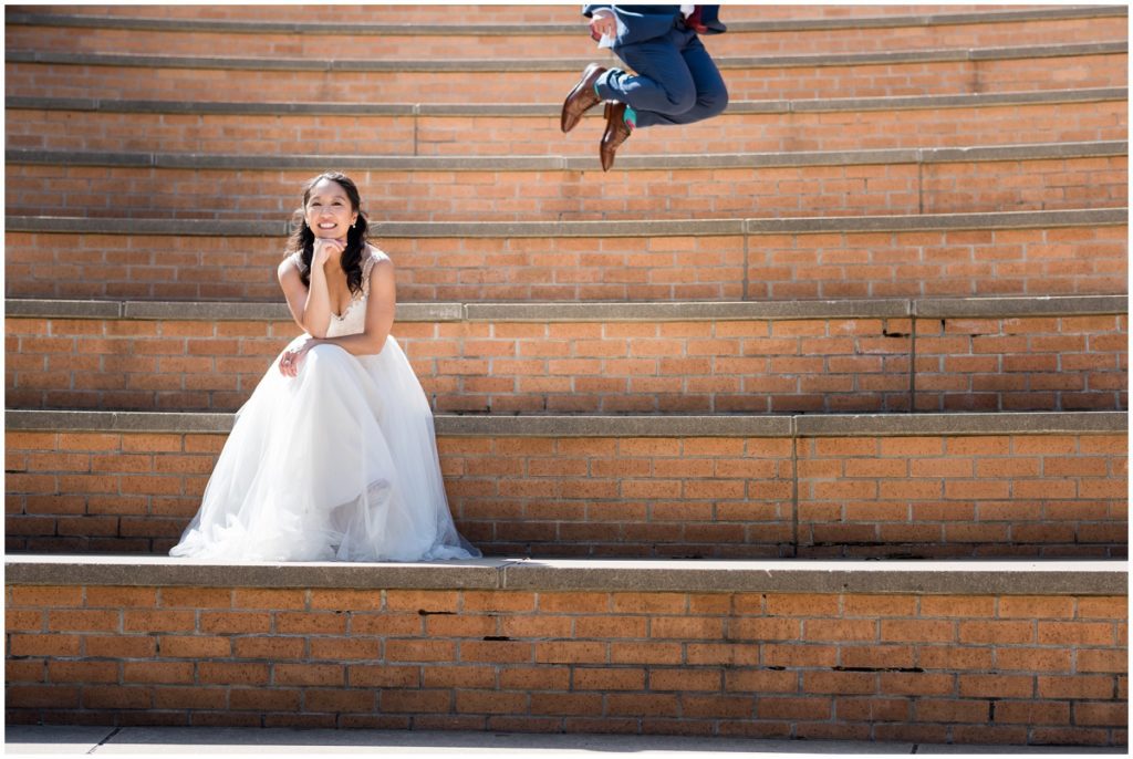 Groom jumping while bride poses in MIT