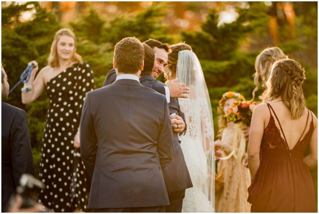 Groom and bride hugging friends after ceremony