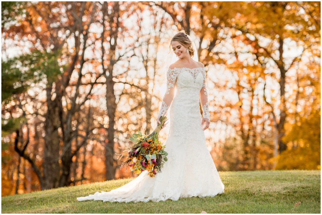 Bride against autumn trees outdoors in NH