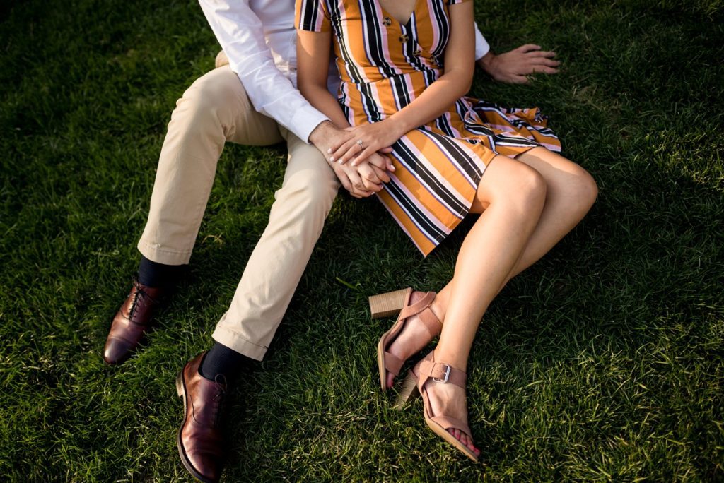 Couple holding hands on grass during engagement session