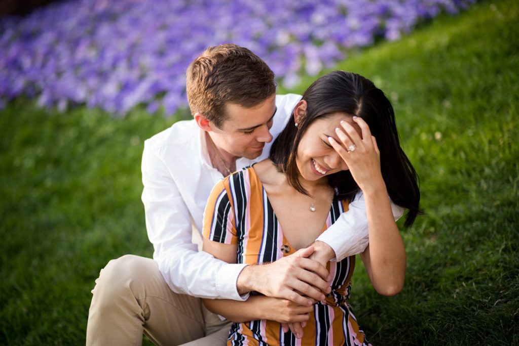 Fiancee smiling while being hugged by fiance on Cambridge City hall lawn