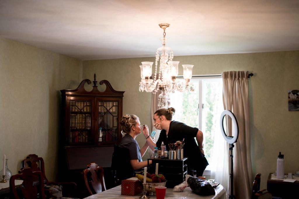 Makeup and hair artist doing bridesmaid's makeup