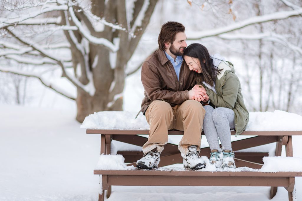 Couple sitting down on a picnic table