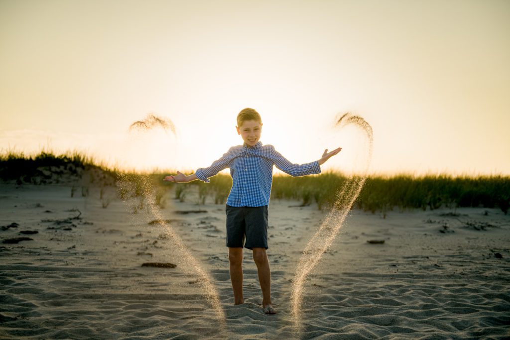 Child throwing sand during sunset Cape Cod Family Pictures
